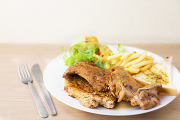 pork and chicken steak with salad and french fried