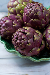 Fototapeta premium Fresh big Romanesco artichokes green-purple flower heads ready to cook