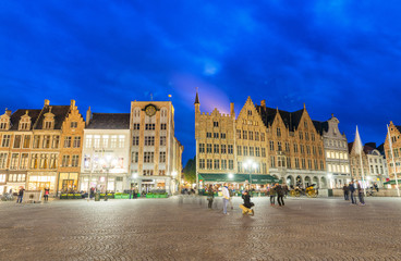 Fototapeta na wymiar BRUGES, BELGIUM - MARCH 2015: Tourists visit ancient medieval city at night. Brugge attracts more than 2 million people annually
