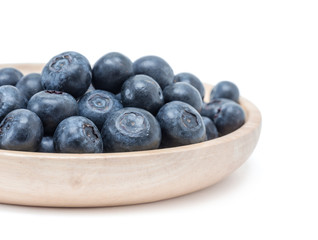 blueberry fruit in wooden plate isolated on white background