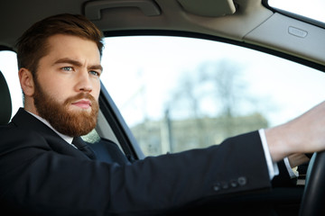 Fototapeta na wymiar Serious bearded business man driving car