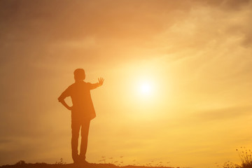Silhouette of woman praying over beautiful sky background
