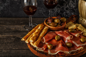 Prosciutto, cracker, bread sticks with red wine.