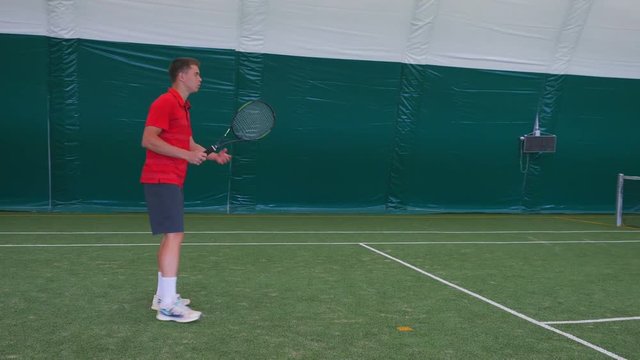 Man playing tennis with young guy on grass court