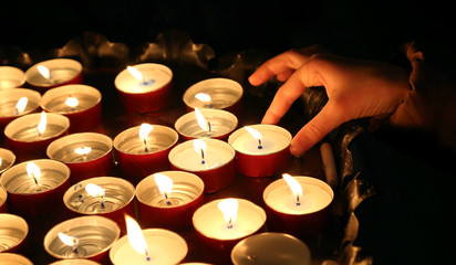 child lights a candle during the religious ceremony