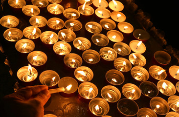 person lights a candle during the religious ceremony