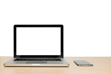 Open laptop with isolated white screen and mobile phone on wooden