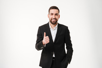 Happy young businessman showing thumbs up gesture.