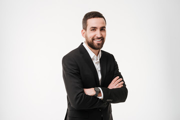 Smiling young businessman posing with arms crossed.
