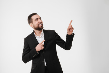 Cheerful young businessman pointing to copyspace.