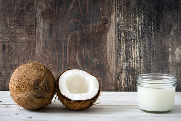 Coconut and coconut milk on white wooden table
