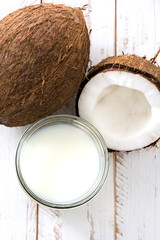 Coconut and coconut milk on white wooden table
