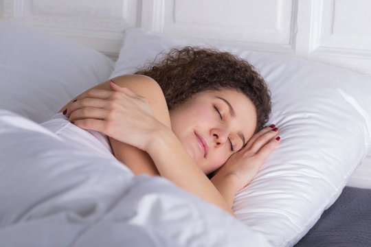 Beautiful girl sleeping in bed alone.