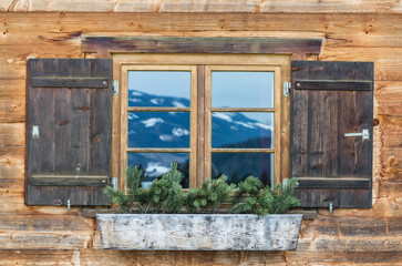 Vintage Window of old alpine house. Wooden rustic background.