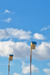 Two yellow birdhouses on the blue sky background