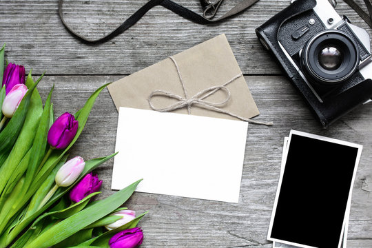 blank greeting card and envelope with retro camera, blank photos and tulip flowers