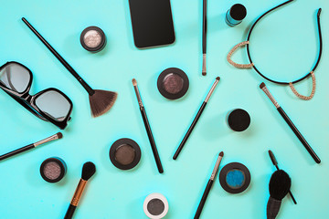 Various cosmetics and brushes on blue background