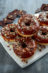 donut rings with white and dark chocolate chippings and icing served on board