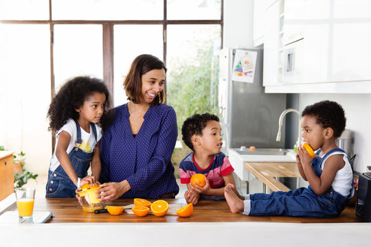 Des enfants font du jus d'orange avec leur m&egrave;re
