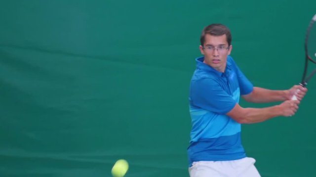 The athlete holds the racket with both hands and playing tennis