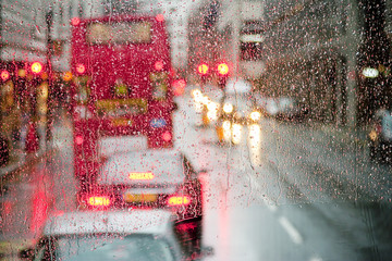 Regen in Londen zicht op rode bus door regengespikkeld raam