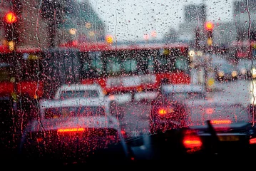 Foto op Plexiglas Regen in Londen zicht op rode bus door regengespikkeld raam © Raimond Klavins