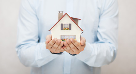 Small toy house in hands 
