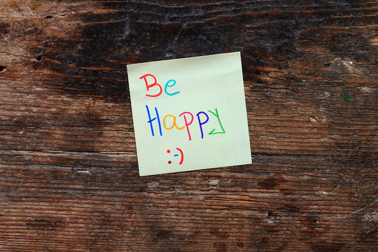 Motivation message Be happy on wooden table 