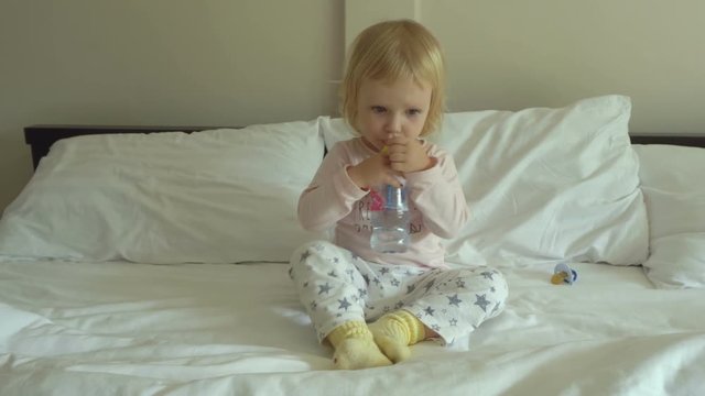 Little cute blonde girl drinks water