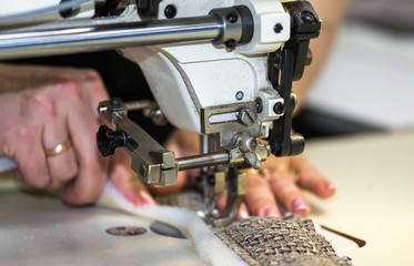 Hands of a woman who works on the sewing machine