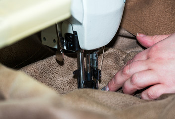 Hands of a woman who works on the sewing machine
