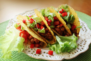 Mexican food - tacos with meat, lettuce and tomatoes