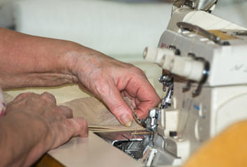 Hands of a woman who works on the sewing machine