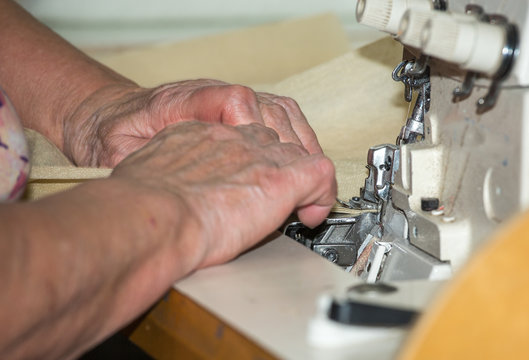 Hands of a woman who works on the sewing machine