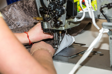Hands of a woman who works on the sewing machine