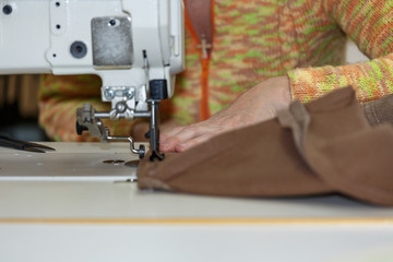 Hands of a woman who works on the sewing machine