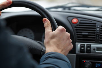 Male hand on a steering wheel