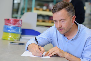 Man sat at table writing