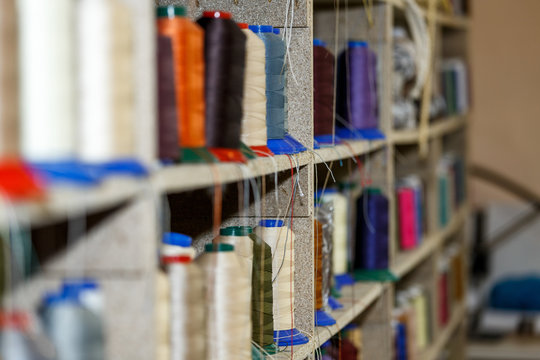 Spools of thread which are on the shelves and the loom