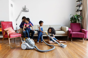 Une famille passe l'aspirateur dans le salon