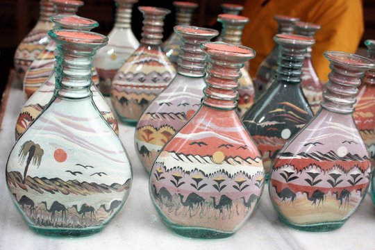 Traditional souvenirs in bottles with sand shows desert and camels, Petra in Jordan 