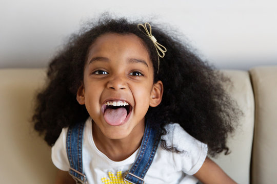 Portrait d'une petite fille qui tire la langue en riant