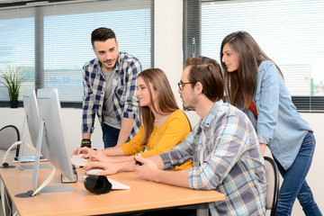 Fototapeta premium group of young cool hipster creative business people in casual wear working together in a meeting room of startup company looking at photography on computer