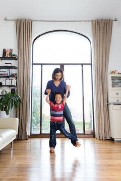 Une maman fait marcher son enfant sur ses pieds