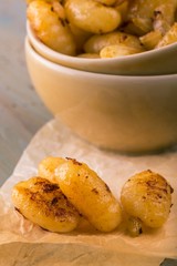 Few pieces of gnocchi in front of portion in bowl