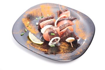 shish kebab on a plate on a white background
