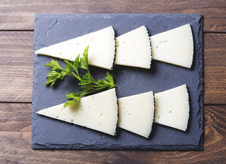 Top view of sliced cheese on slate plate. Horizontal shoot.