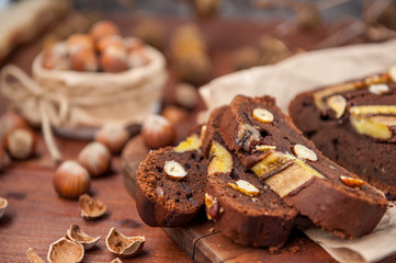 Chocolate cake with banana and hazelnut on a wooden background