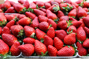 Packages of juicy strawberries for sale on the greek market. Horizontal. Close up.