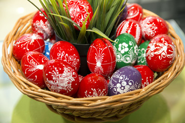 Colorful handmade easter eggs in a wooden basket as easter present